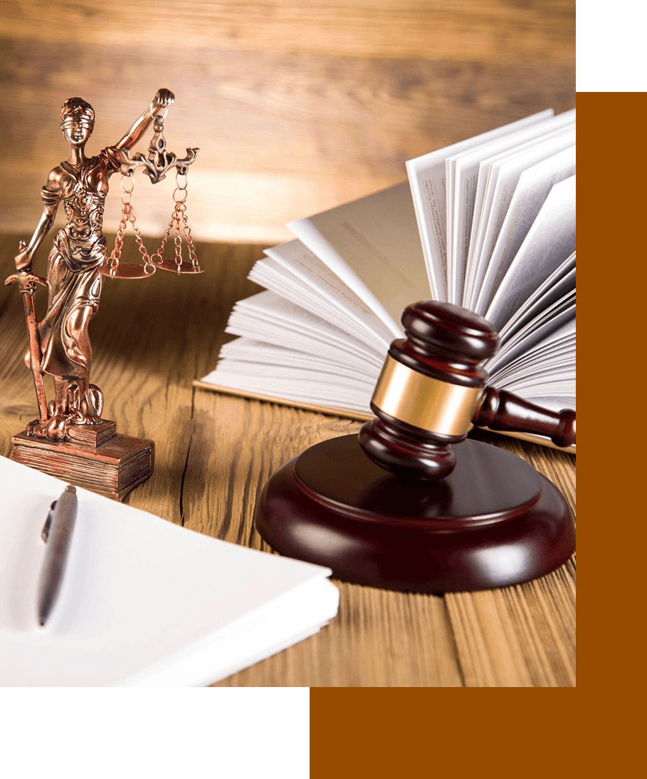 A wooden table with a gavel and statue of justice.